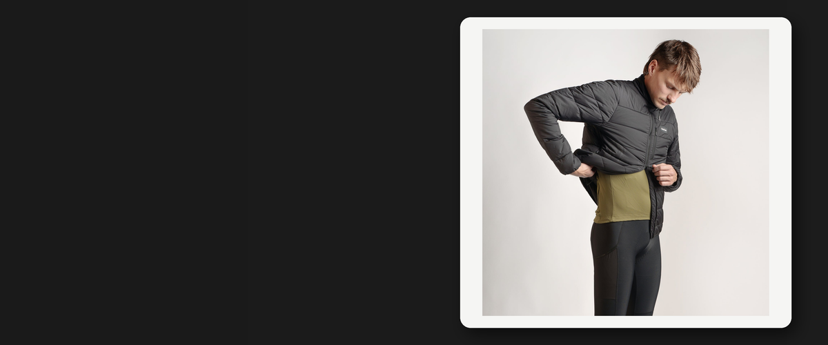Ciclista abrochándose una chaqueta técnica acolchada de ciclismo en tonos oscuros, foto de producto real, oferta de ropa de ciclismo de otoño en ARS Bike Parts